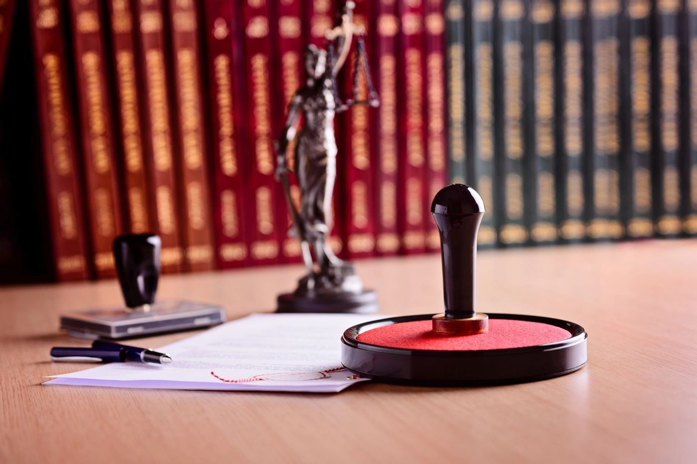 Notary stamp, pen and documents on an office desk